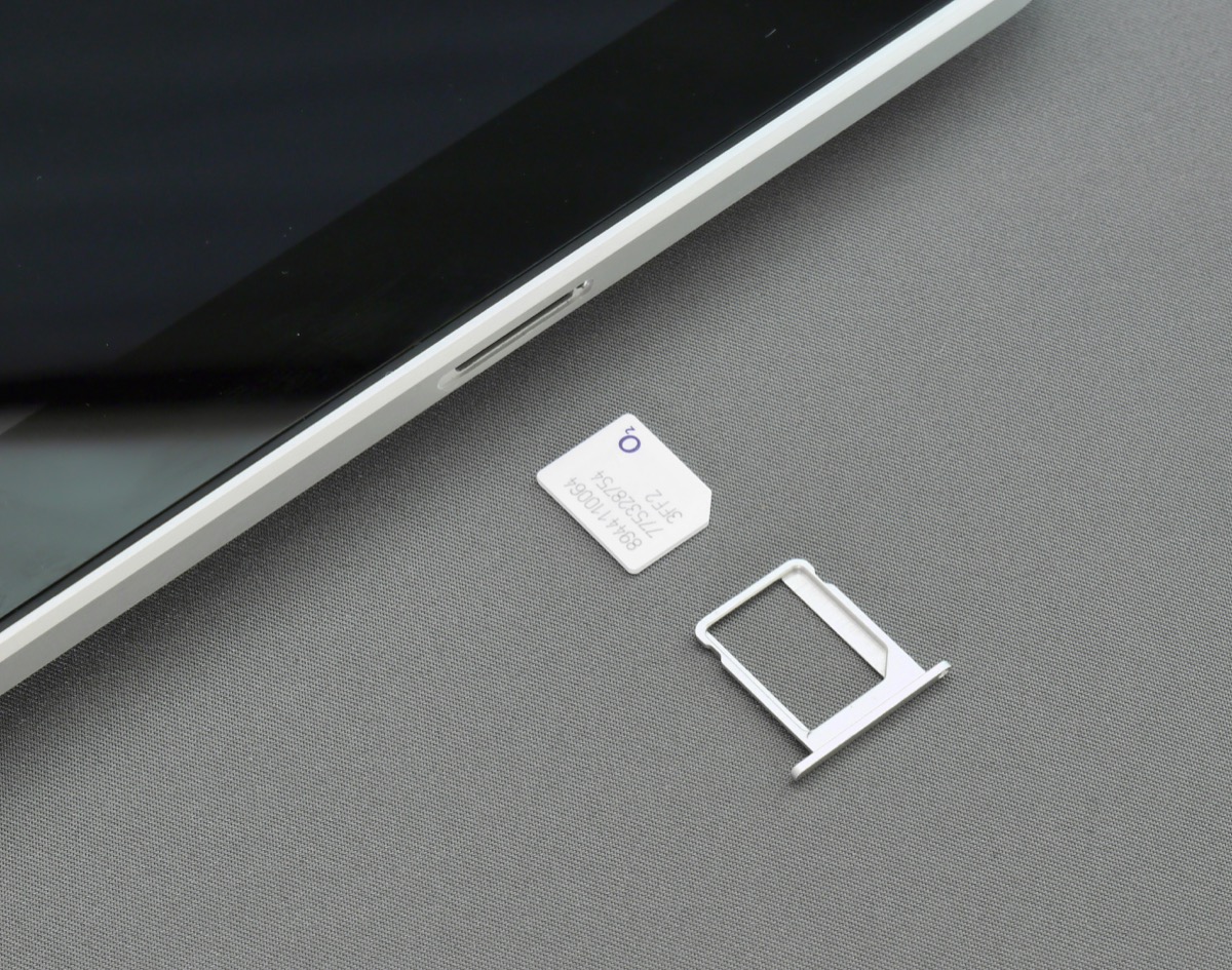A Mongolian tourist SIM card next to a smartphone SIM tray, ready to insert